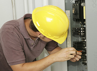 Berg electrician working inside an electrical panel