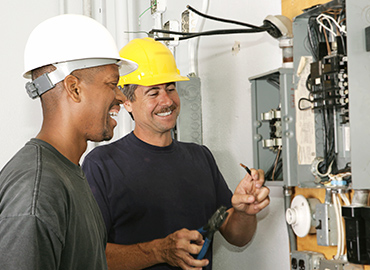 Two Berg electricians collaborating at an electrical panel